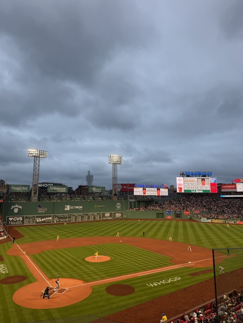 Fenway Park under the lights at dusk, with the Green Monster in left field